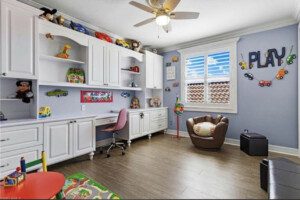 Playroom with white cabinets and baseball chair.