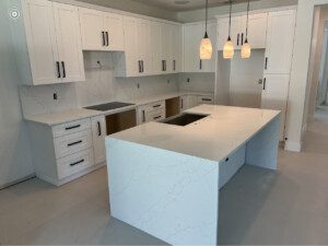 White kitchen island with marble countertop.