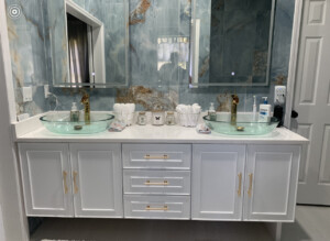 A washroom with two basins of glass and white interior.