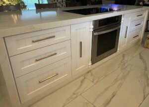 White kitchen island with drawers and oven.