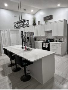 White kitchen island with black bar stools.